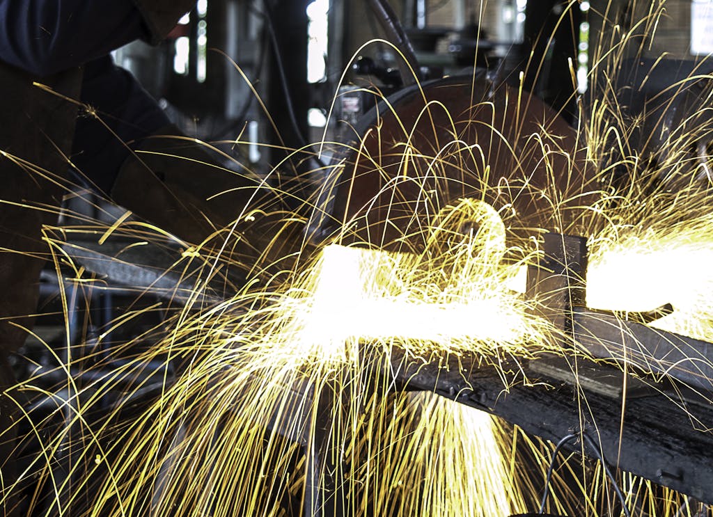 Vibrant sparks fly during welding in a busy workshop, showcasing intense craftsmanship.
